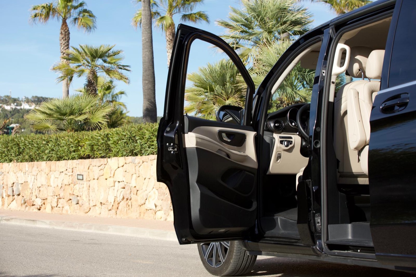 Mercedes V-Class with doors open on an Ibiza road, cream-leather cabin ready for boarding